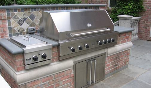 Propane grill at residence with brickwork and tile